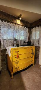 Vestidor amarillo en una habitación con cortinas en La Escondida, en Villa Serrana