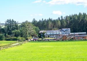 a large house in a field of green grass at Dulrush Lodge Guest House, Restaurant and Self-Catering in Belleek