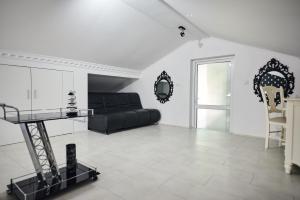 a living room with a black bed and a mirror at La Conac Resort in Hulubeşti