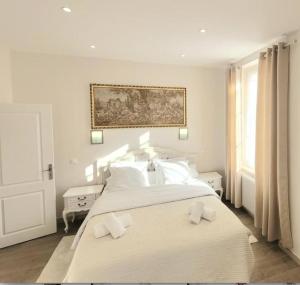 1 dormitorio blanco con 1 cama blanca grande con almohadas blancas en L'ambassadeur - Colmar centre, en Colmar