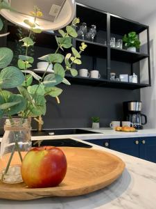 a wooden cutting board with an apple on a kitchen counter at Apartament Botanica - Blisko parku i centrum - by SpaceApart in Jelenia Góra