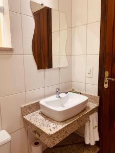 uma casa de banho com um lavatório e um espelho em Pousada Luamar em Paraty