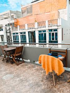an orange blanket on a table and chairs on a balcony at Shelter by the hill 104 in Ho Chi Minh City