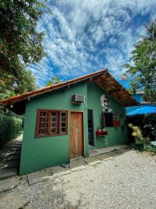 una pequeña casa verde con una cara lateral en Mambembe Hostel - Ilha Grande en Ilha Grande