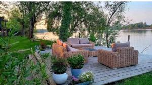 una terraza de madera con sillas de mimbre y una mesa en La Roque de Bas, en La Rivière