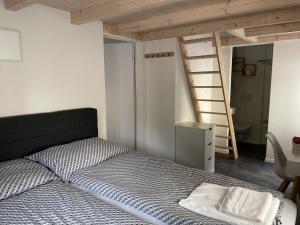 Un dormitorio con una cama y una escalera en una habitación en Hotel Sternen, en Gurtnellen