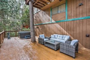 un patio con muebles de mimbre en una terraza de madera en Woodsy Twin Peaks Getaway with Hot Tub and Views! en Twin Peaks