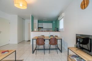 a kitchen with a table and chairs in a room at LaConciergerieJonzac, Appartement Le Carré des Antilles 2 in Jonzac