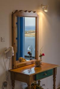 een spiegel op een tafel in een kamer met een raam bij Agnadi studios in Maltezana