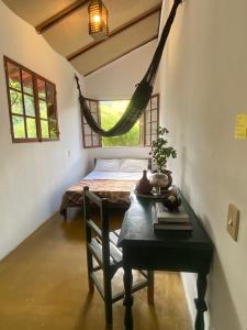 萨纳Casa Maia Sana Hostel的客房设有桌子、床和吊床。