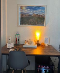 a desk with a lamp and a picture on the wall at Itinere Rooms in Granada