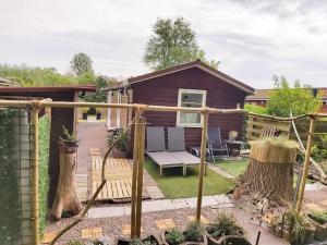 a backyard with a wooden deck with a bench and a house at Tiny house Schoorl Bergen NH in Warmenhuizen