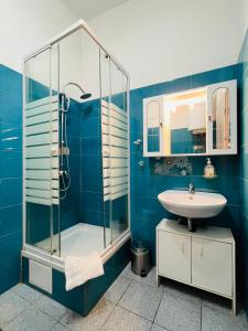 y baño azul con lavabo y ducha. en Apartments Katrca Ljubljana en Liubliana
