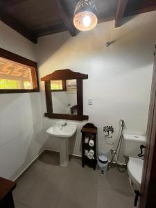 a bathroom with a sink and a mirror and a toilet at Aymara Lodge in Poconé