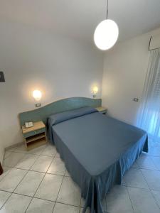 a bedroom with a blue bed and a table at Albergo Désirée 2 in Alba Adriatica