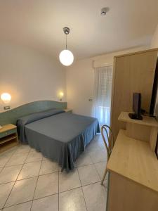 1 dormitorio con 1 cama y TV en Albergo Désirée 2, en Alba Adriatica