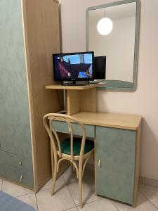 a desk with a computer and a chair in a room at Albergo Désirée 2 in Alba Adriatica