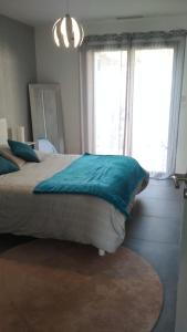 ein Schlafzimmer mit einem großen Bett mit blauen Kissen in der Unterkunft Chambre d'hôte " Ô Soleil " in Vaison-la-Romaine