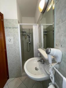 y baño con lavabo y ducha. en Albergo Désirée 2, en Alba Adriatica