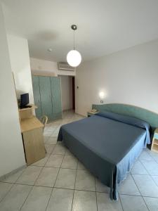 sypialnia z niebieskim łóżkiem w pokoju w obiekcie Albergo Désirée 2 w miejscowości Alba Adriatica