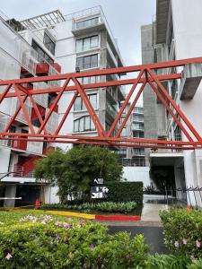 un puente rojo frente a un edificio en Apartamento moderno 1 habitación y 1 baño, área Cayalá Embajada USA CASH ONLY, en Guatemala