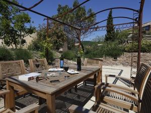 a wooden table and chairs on a patio at La Palombe in Octon