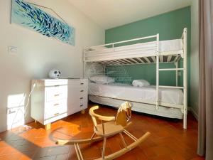 a bedroom with a bunk bed and a chair at Jolie Maison cœur de Capbreton in Capbreton