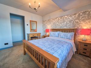 een slaapkamer met een bed met een blauw en wit dekbed bij Drysgol Lakeside - Bala Lake in Bala