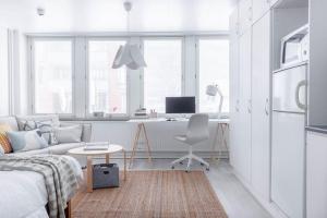 Studio for a business traveler في هلسنكي: غرفة معيشة بيضاء مع أريكة ومكتب