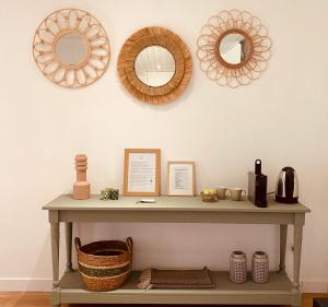 a shelf with three mirrors and a basket on a wall at Clos Labellie - Gîte et Chambre d'Hôtes à Saint-Emilion in Lugaignac