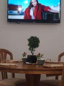 TV colgada en una pared sobre una mesa de madera en City Diamond Apartment, en Skopje
