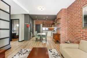 una sala de estar con una pared de ladrillo y una mesa en The Vantage 209 en Johannesburgo