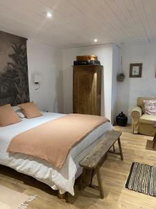 a bedroom with a bed and a bench in it at Clos Labellie - Gîte et Chambre d'Hôtes à Saint-Emilion in Lugaignac