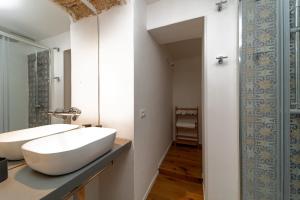 een badkamer met een witte wastafel en een spiegel bij Casa Gagini in Palermo +16 foto's