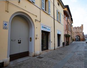 an alley with a building with an archway on a street at La Dimora delle Emozioni - Il Fascino del Centro Storico e L'adrenalina dell'Autodromo in Imola