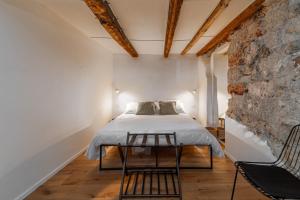 een slaapkamer met een bed en een stenen muur bij Casa Gagini in Palermo