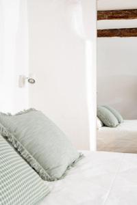 een witte slaapkamer met 2 bedden en een spiegel bij Casa Gagini in Palermo