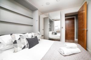1 dormitorio con 1 cama grande y 2 toallas. en Stunning Modern Apartment close to Hyde Park by UnderTheDoormat, en Londres