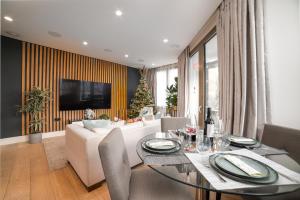 uma sala de estar com uma mesa e um sofá em Stunning Modern Apartment close to Hyde Park by UnderTheDoormat em Londres