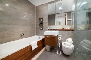 y baño con bañera, aseo y lavamanos. en Stunning Modern Apartment close to Hyde Park by UnderTheDoormat, en Londres