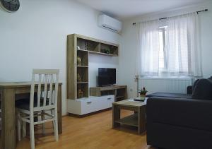 uma sala de estar com um sofá, uma mesa e uma cadeira em Aster Apartments em Belgrado