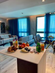 a living room with a table with food on it at C Tower Apartments in Netanya