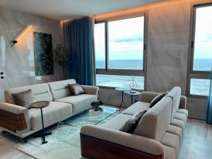 a living room with two couches and a large window at C Tower Apartments in Netanya