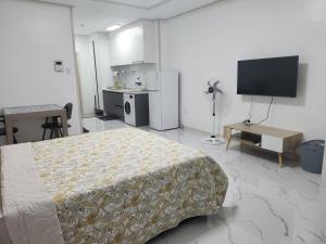1 dormitorio con 1 cama y TV de pantalla plana en Daily Studio Condo For Rent in Clark Pampanga with lovely mountain view, en Mabalacat