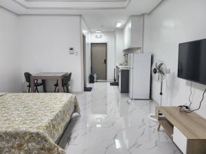 Habitación con cama, TV y cocina. en Daily Studio Condo For Rent in Clark Pampanga with lovely mountain view, en Mabalacat