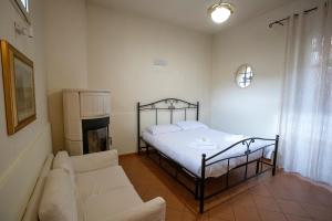 a bedroom with a bed and a couch at La Dimora delle Emozioni - Il Fascino del Centro Storico e L'adrenalina dell'Autodromo in Imola
