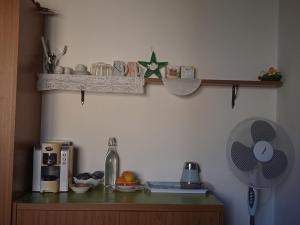 a kitchen with a counter with a fan and a shelf at Affittacamere Cooperativa Olistica in Mamoiada