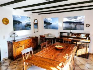 comedor con mesa de madera y sillas en Walnut House en Herdwangen-Schönach