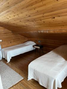 two beds in a room with a wooden ceiling at Lohelanranta in Kemijärvi