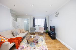 sala de estar con sofá y mesa en Newly refurbished charming 3-Bed House in Barking, en Barking
